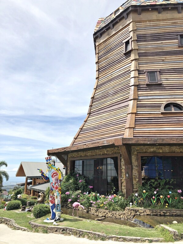 A building with a unique curved roof and a statue of a character in a colorful costume.