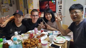 Un grupo de personas sentadas a una mesa con comida y bebidas.