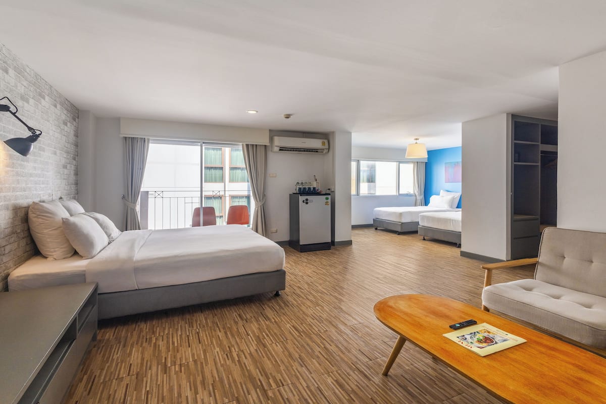 Ein Hotelzimmer mit Bett, Schreibtisch, Sofa, Couchtisch und Kleiderschrank.
