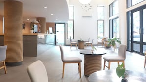 A modern lobby with a reception desk, seating area, and large windows. - Journeyhub Pattaya Central (Pattaya)