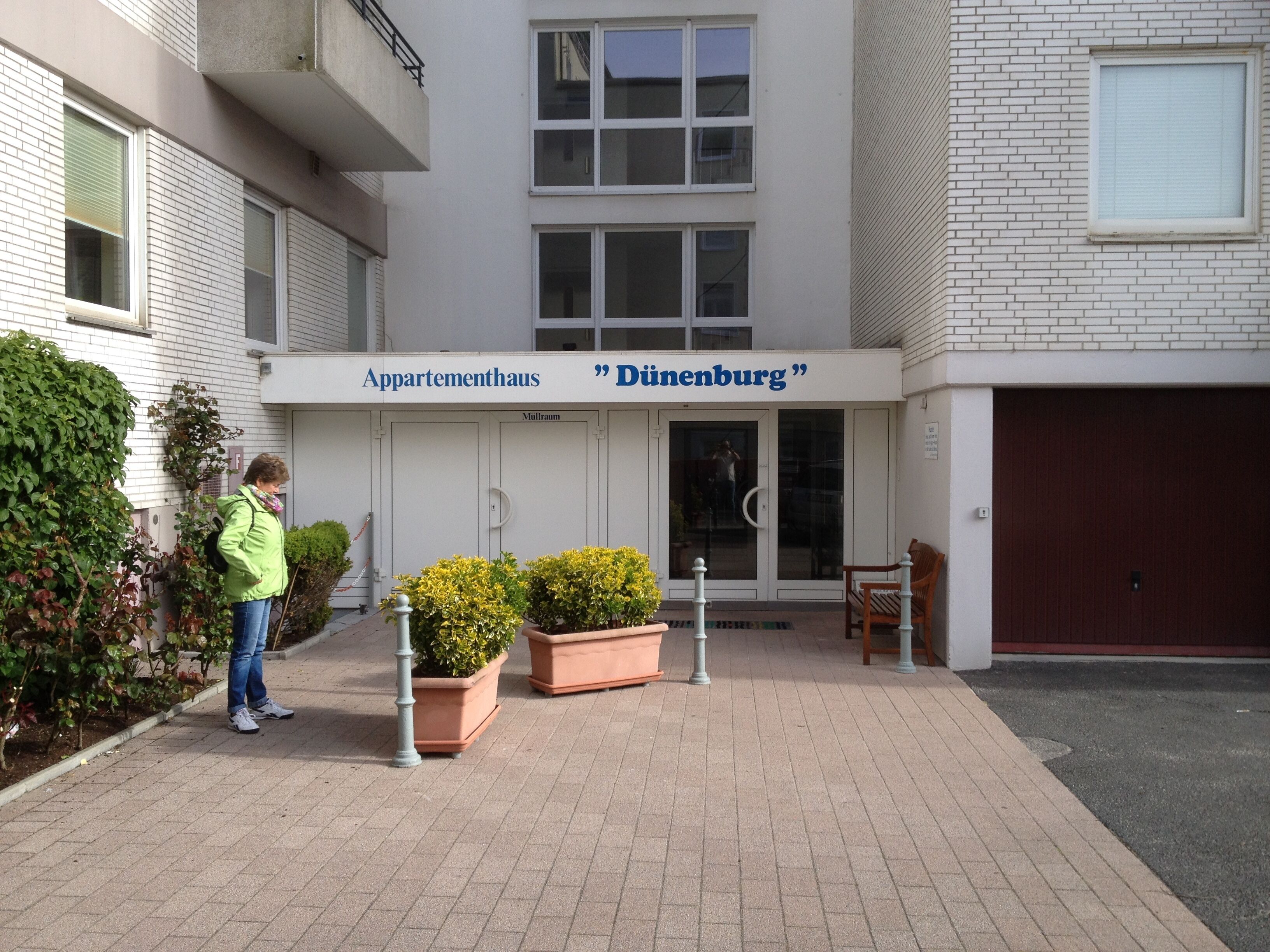 Un edificio con un letrero que dice 'Appartementhaus Dürenburg' y una persona parada frente a él.