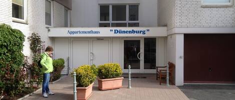 Un edificio con un letrero que dice 'Appartementhaus Dürenburg' y una persona parada frente a él.