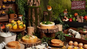 A rustic-themed display with various food items, including pastries and fruits, arranged on wooden surfaces and tree stumps. - KEIO PRELIA HOTEL SAPPORO (Sapporo)