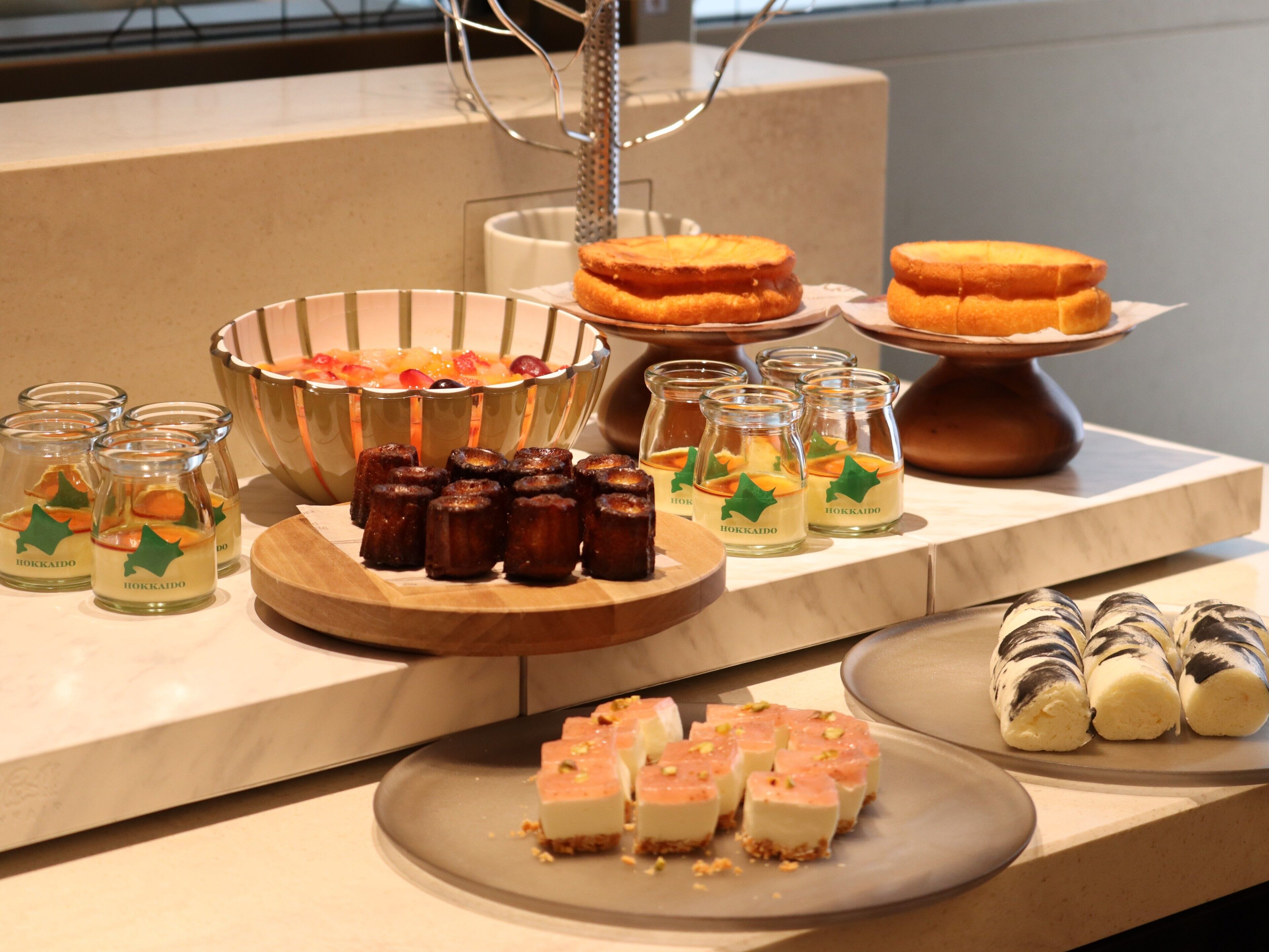 Uma mesa de buffet com diversos alimentos, incluindo sobremesas e bebidas.