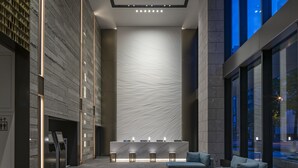 A modern lobby with a central seating area, a reception desk, and a large wall with a textured pattern. - KEIO PRELIA HOTEL SAPPORO (Sapporo)