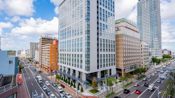 A modern hotel with a prominent glass facade, multiple floors, and a flat roof. - KEIO PRELIA HOTEL SAPPORO (Sapporo)