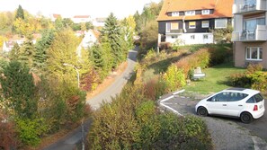 Stroll through the serene surroundings to a charming home with a red-tiled roof.