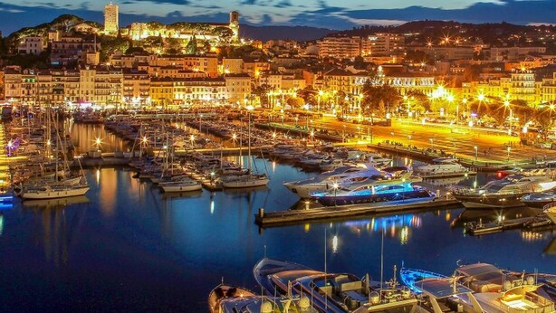 A marina with boats docked, a prominent tower, and buildings along the waterfront. - Cannes, 2 rooms Furnished 3 stars 10 mn from the Palais and the beach (Cannes)