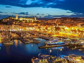A marina with boats docked, a prominent tower, and buildings along the waterfront. - Cannes, 2 rooms Furnished 3 stars 10 mn from the Palais and the beach (Cannes)