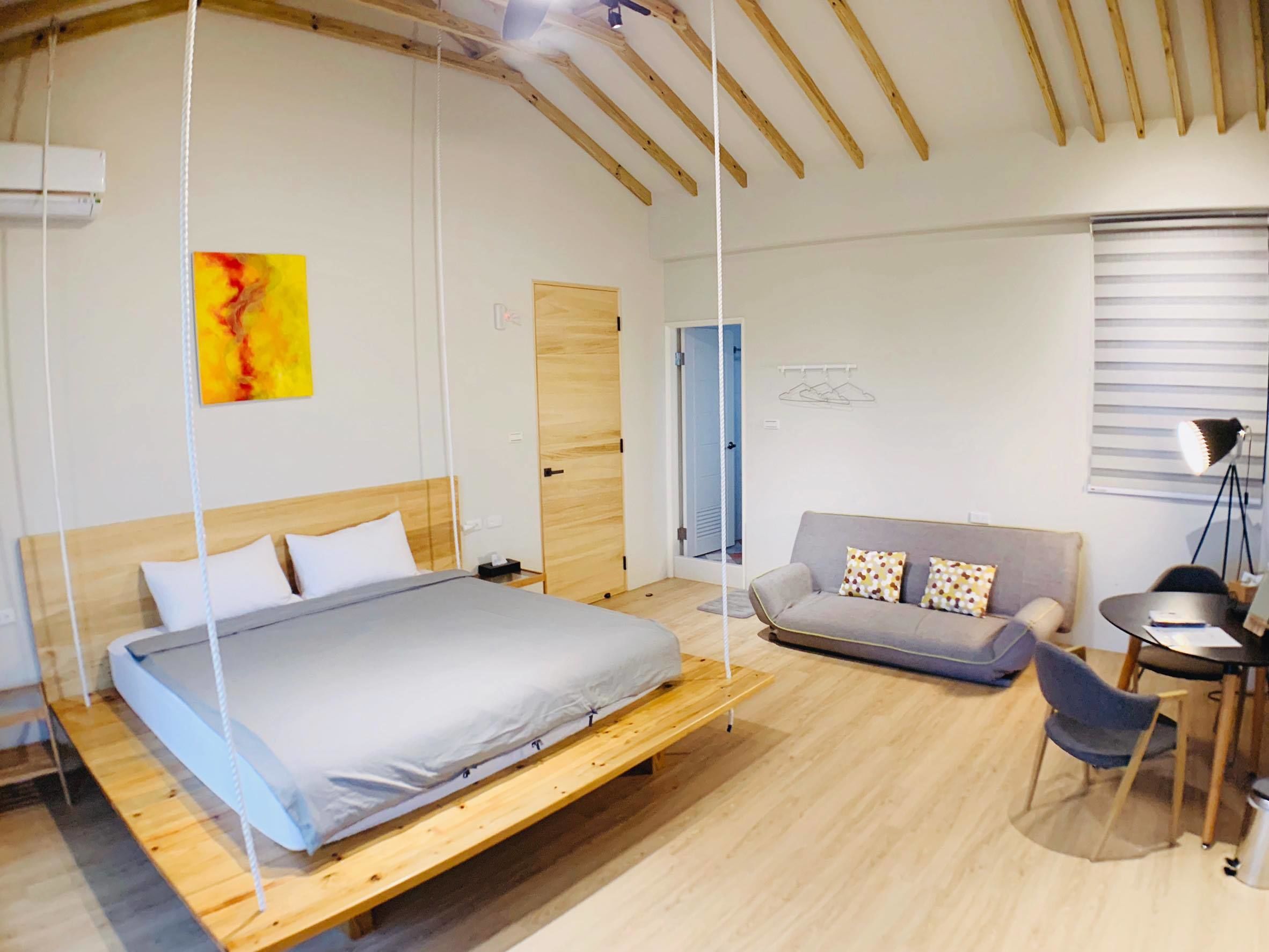 Une chambre à coucher moderne avec un lit, un canapé et un bureau.