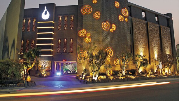 A hotel with a modern design, featuring a prominent logo and illuminated spiral patterns on the facade. - Yin Shui Han Motel (Kaohsiung)