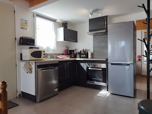 A compact kitchen with a dishwasher, microwave, oven, and a refrigerator. - Villa-4 étoiles-Oversized-Whirlpool bath-Terrace (Angoulins)