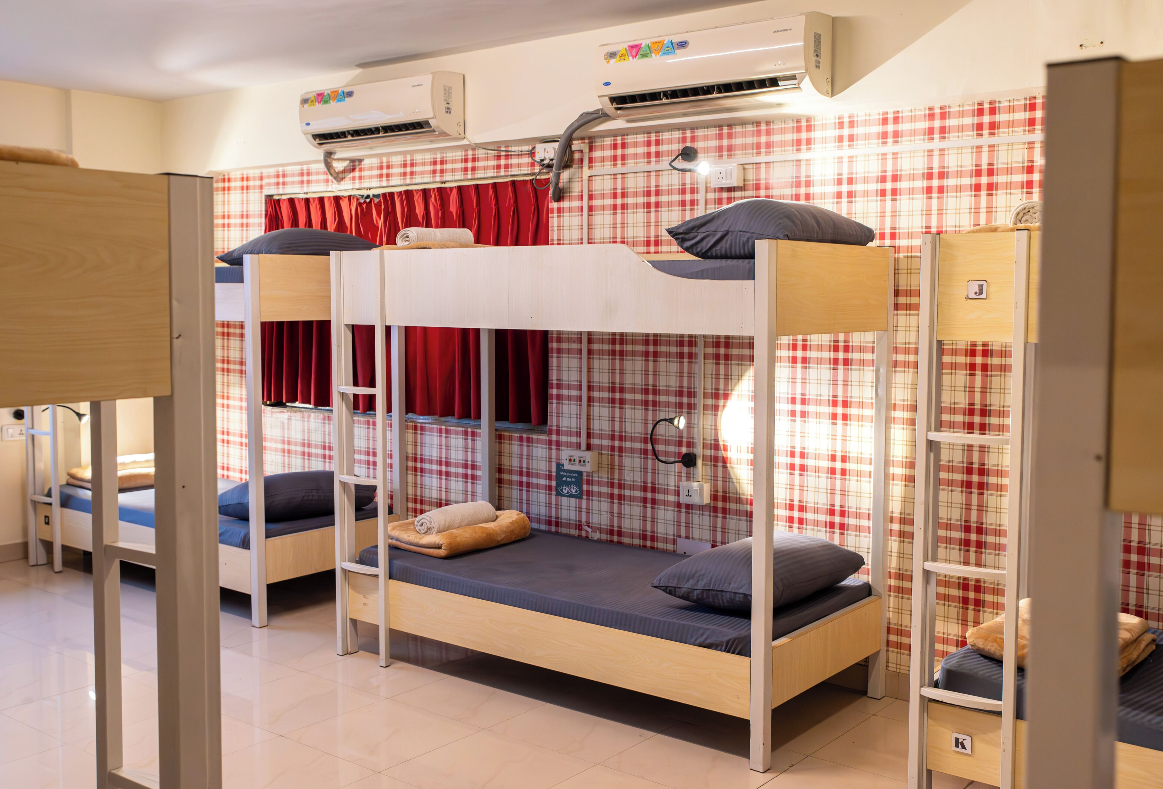 Una camera del dormitorio con letti a castello, una scrivania e una finestra con tende rosse.