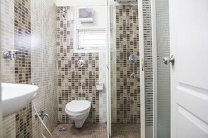A bathroom with a toilet, sink, and shower area. - SKYLA Serviced Apartments Banjara Hills (Hyderabad)
