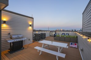 A rooftop patio with a grill, seating area, and a view of the city skyline. - 🥳​🎉  KILLER ROOFTOP LOUNGE WITH FIRE PIT & BBQ (Nashville)