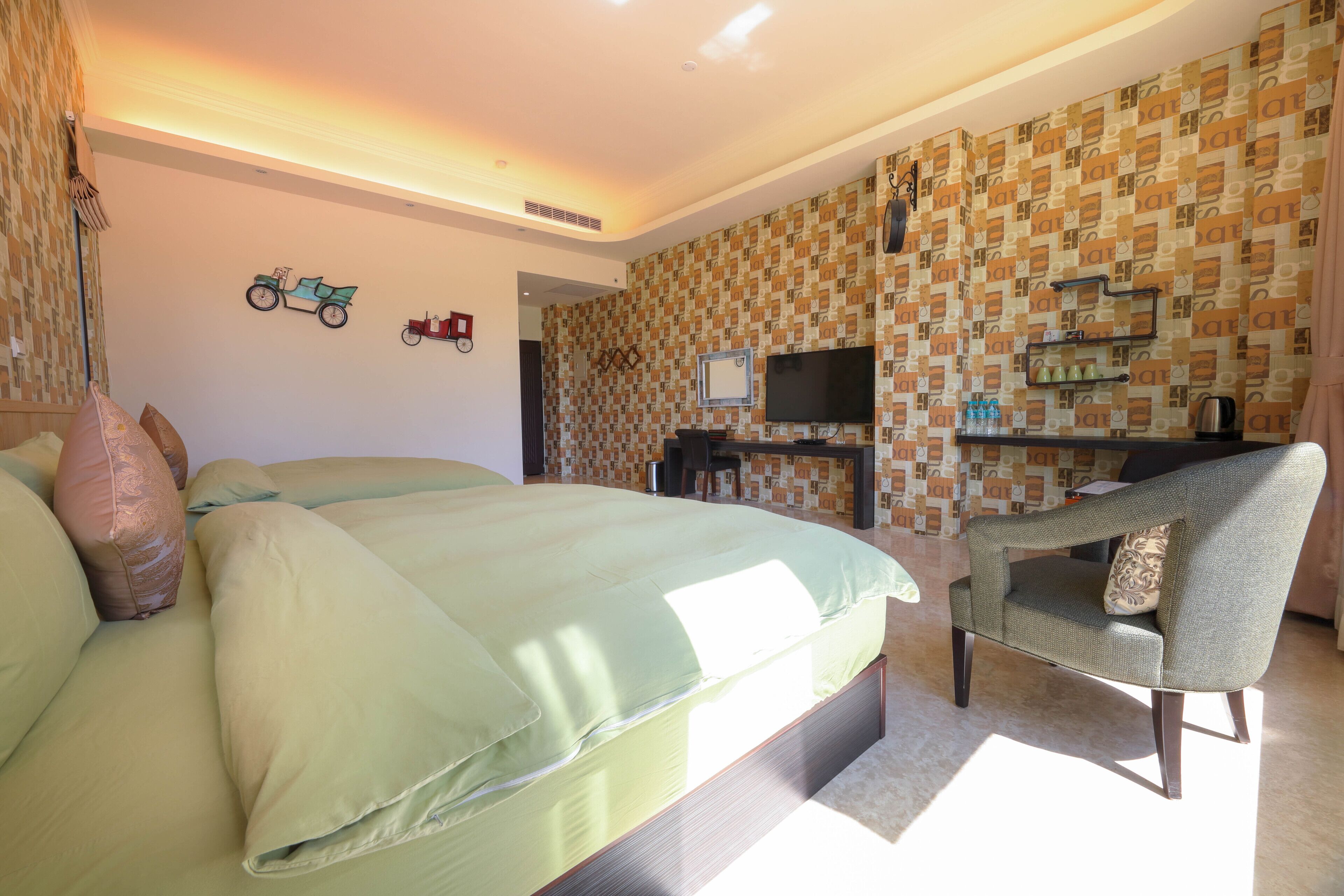 Un dormitorio con cama, una silla, un televisor y una estantería con botellas.