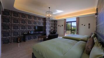 Quarto com parede de pedra, um lustre, televisão e uma grande janela.