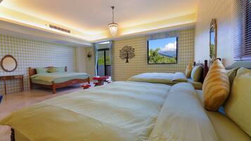 A spacious bedroom with two beds, a wooden nightstand, a mirror, and a window with a view of the outdoors.