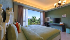 A bedroom with a large bed, a television, and a view of palm trees. - Floral Land B&B (Shoufeng)