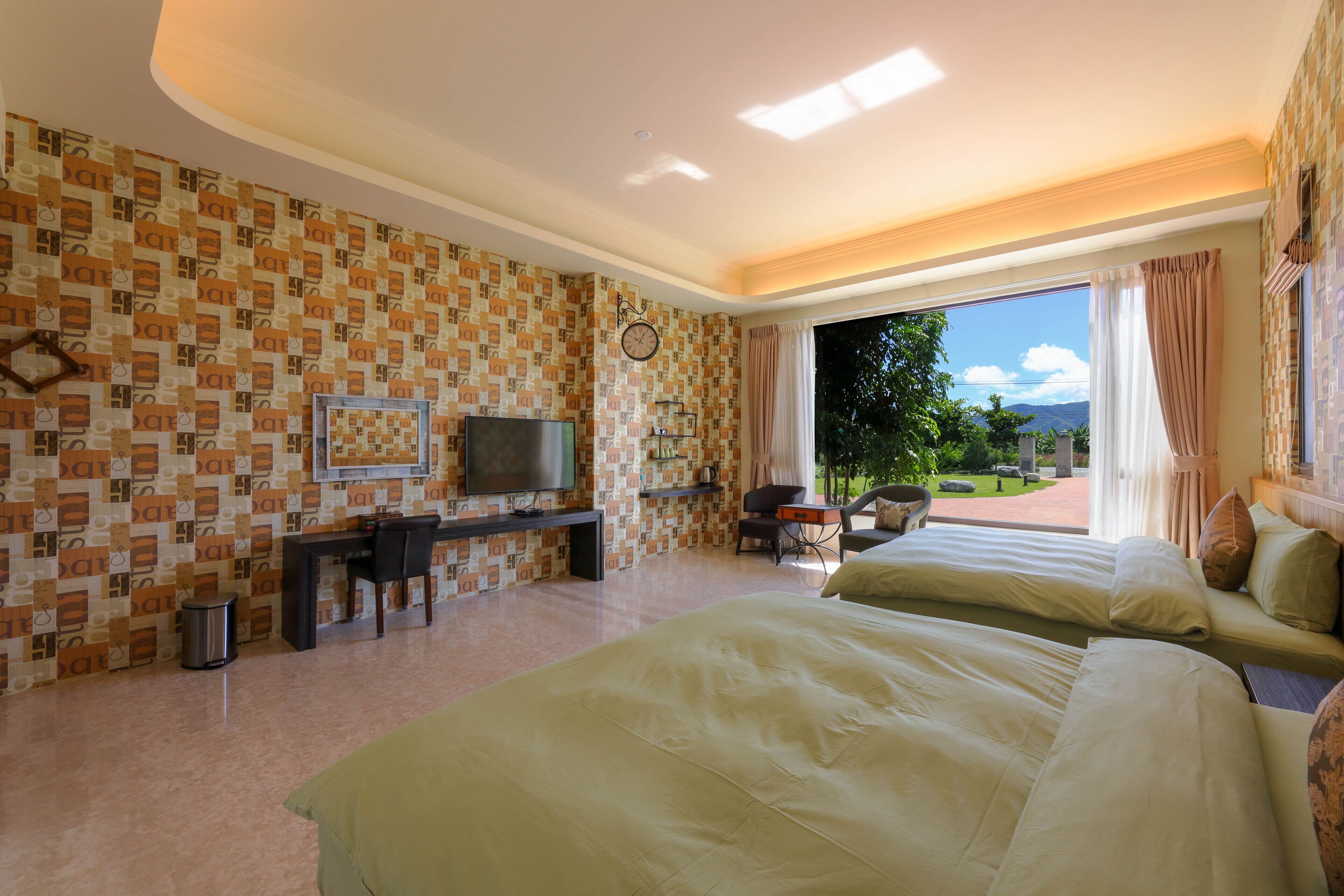 Habitación de hotel con una cama grande, un escritorio con silla, televisión y vistas al exterior.