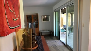 Un couloir avec une porte vitrée donnant sur un patio extérieur.