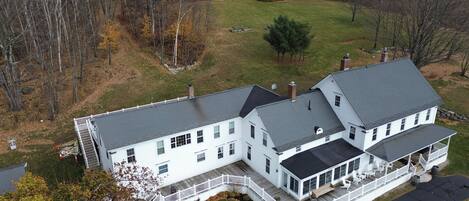 A large, two-story house with a wrap-around porch and a covered front porch.