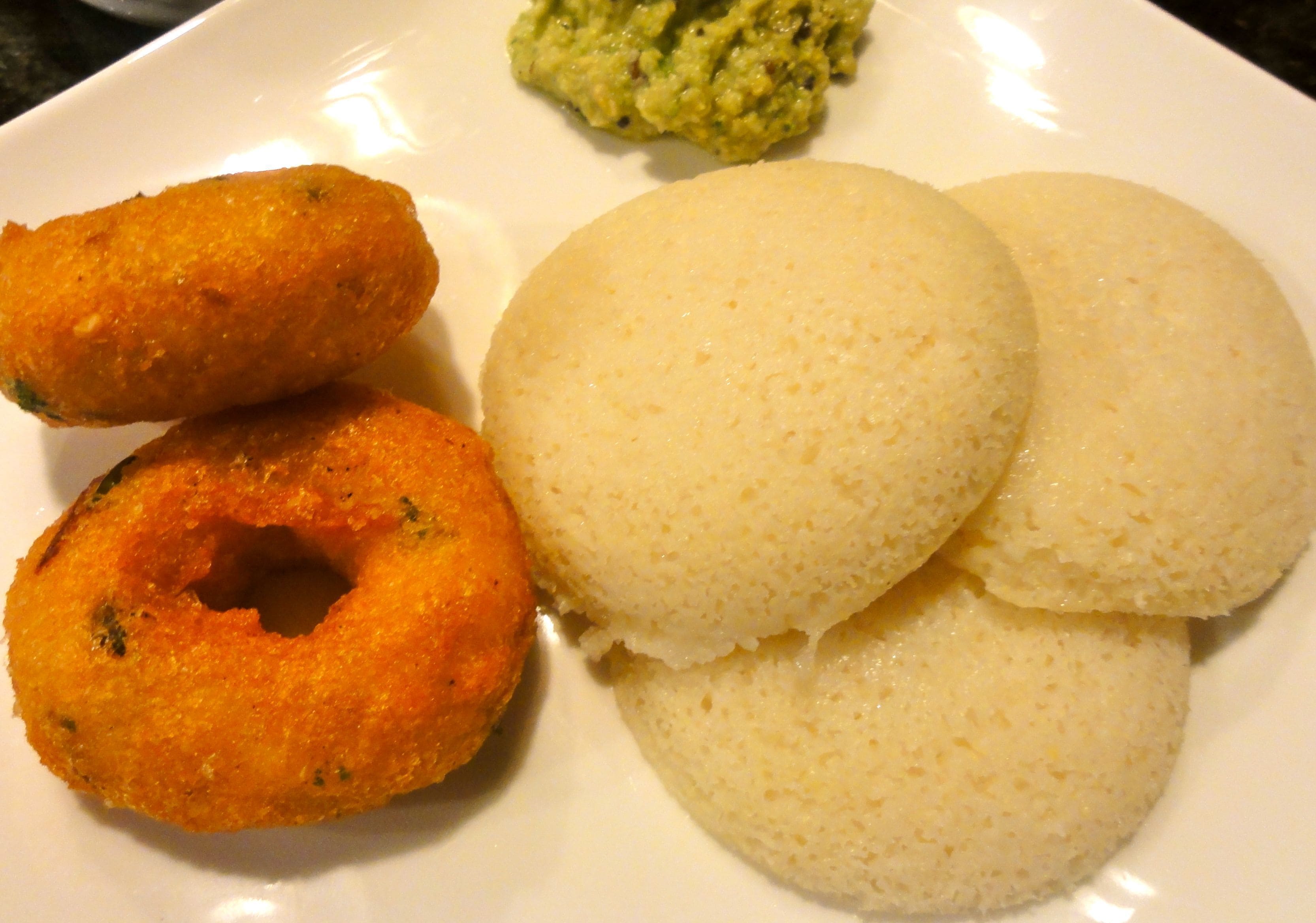 A plate with two white, round, flat items and two golden-brown, cylindrical items.