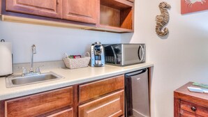 A kitchen with wooden cabinets, a stainless steel sink, a microwave, and a dishwasher.
