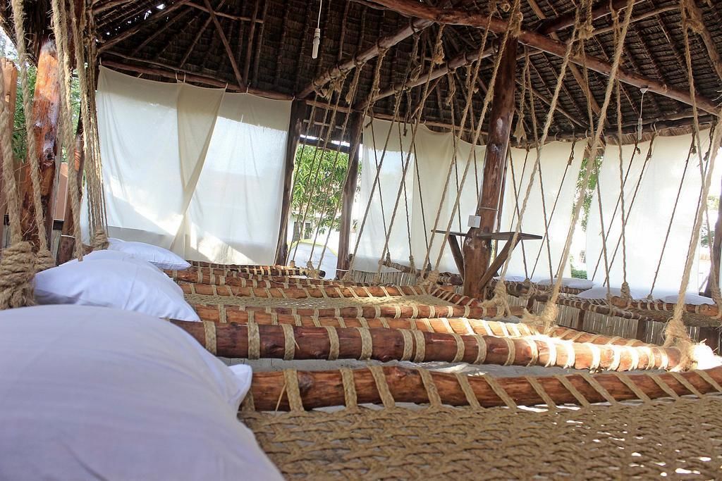 A traditional thatched-roof hut with woven beds and a simple, rustic interior.