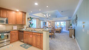 A spacious kitchen with wooden cabinets, a built-in microwave, and a large island.