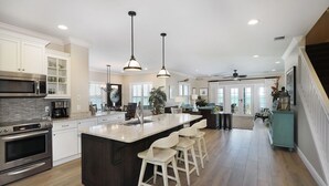 A spacious kitchen with a large island, stainless steel appliances, and pendant lighting. - Waterfront Luxury Villa (62) with sunset views and boat slip (Marathon)