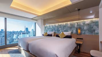 A modern hotel room with a large bed, a city view, and a unique textured wall art.