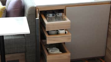 Una kitchenette compacta con armarios de madera y una encimera.