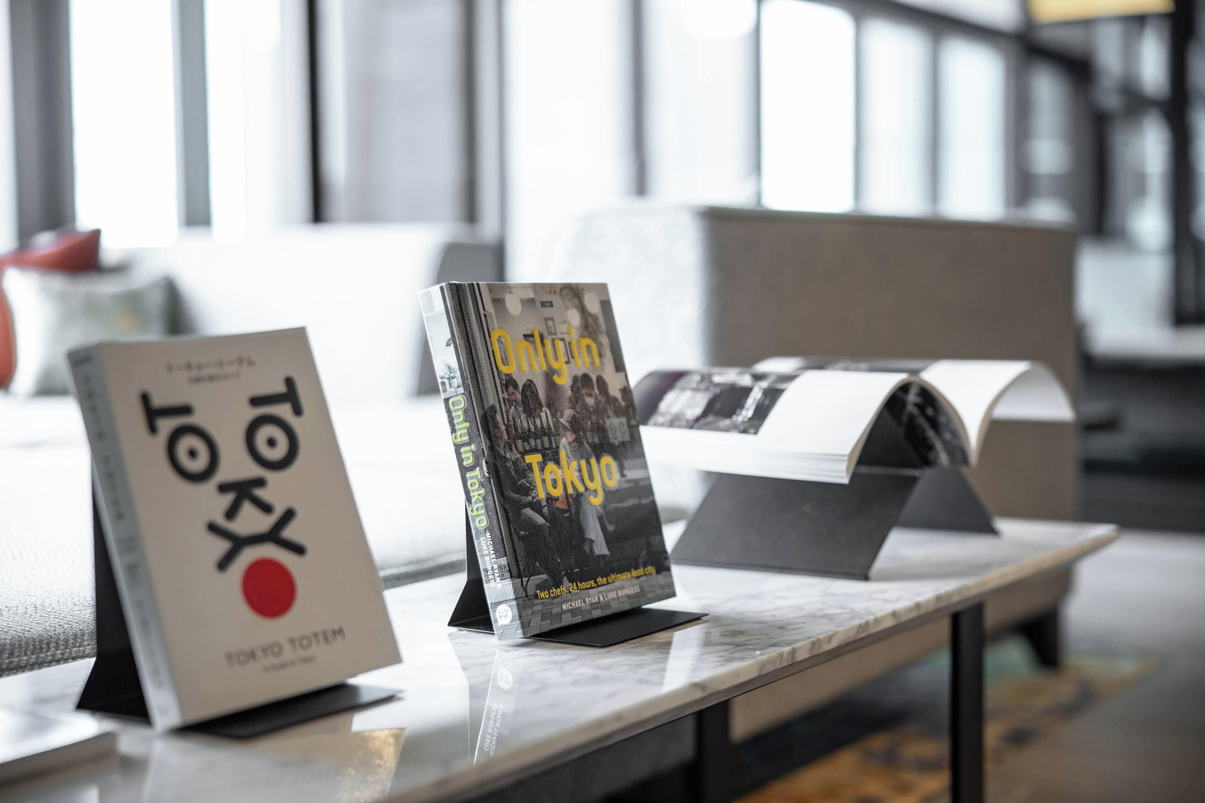 Un libro titulado 'Only in Tokyo' sobre una mesa en un espacio interior moderno y bien iluminado.