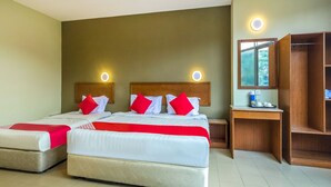 A hotel room with two beds, a wooden nightstand, a mirror, and a small table with toiletries. - Super OYO 828 Comfort Hotel Shah Alam (Shah Alam)