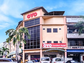 A hotel with a prominent 'OYO Comfort Hotel' sign, large windows, and a flat facade.