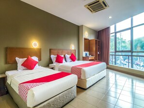 A hotel room with two beds, each with red and white bedding, a nightstand, a dresser, and a large window offering a view of the outside. - Super OYO 828 Comfort Hotel Shah Alam (Shah Alam)