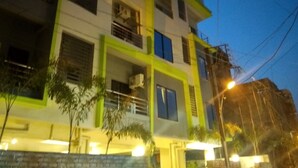 Un immeuble à plusieurs étages doté de balcons, de climatiseurs et d’un lampadaire.
