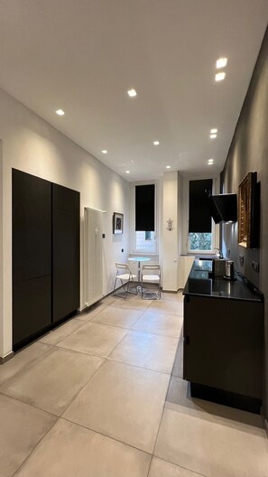 A modern kitchen with a central island, recessed ceiling lights, and a window with a view. - Apartment via Ferrucci 22 (Milan)
