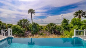 Une piscine d’un bleu éclatant, avec vue sur la plage et l’océan.
