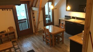 A cozy kitchen with a wooden table and chairs, a built-in oven, and a sink.