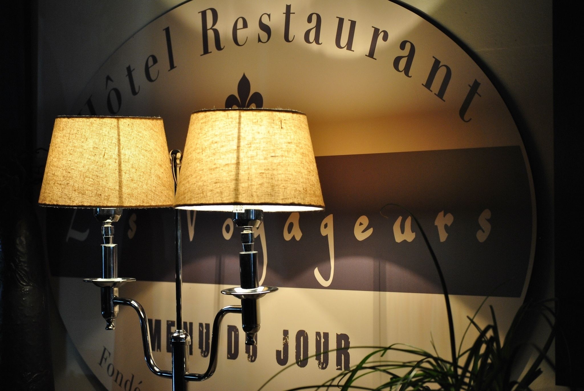 Une enseigne murale portant les mots « Hôtel Restaurant » et « Voyageurs », indiquant l’établissement.