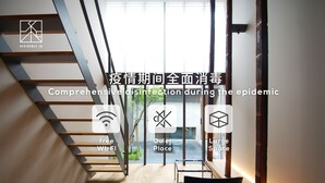 Ein modernes Interieur mit Treppe, einem Sessel und Blick ins Freie.