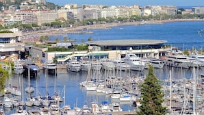 Una marina con numerose imbarcazioni ormeggiate, circondata da edifici e con vista sul mare.