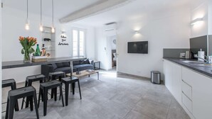 Una cucina moderna con zona pranzo, divano e TV a parete.