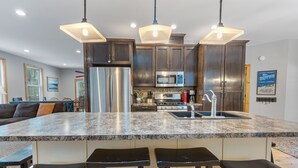 Eine moderne Küche mit Granit-Arbeitsplatten, Edelstahlgeräten und Barhocker.