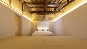 Une chambre avec un grand lit, des poutres apparentes en bois au plafond et un plancher de couleur claire.