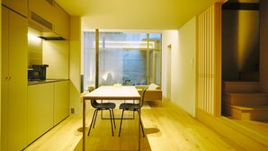 Une cuisine moderne avec un coin repas, un plancher en bois et une grande fenêtre.