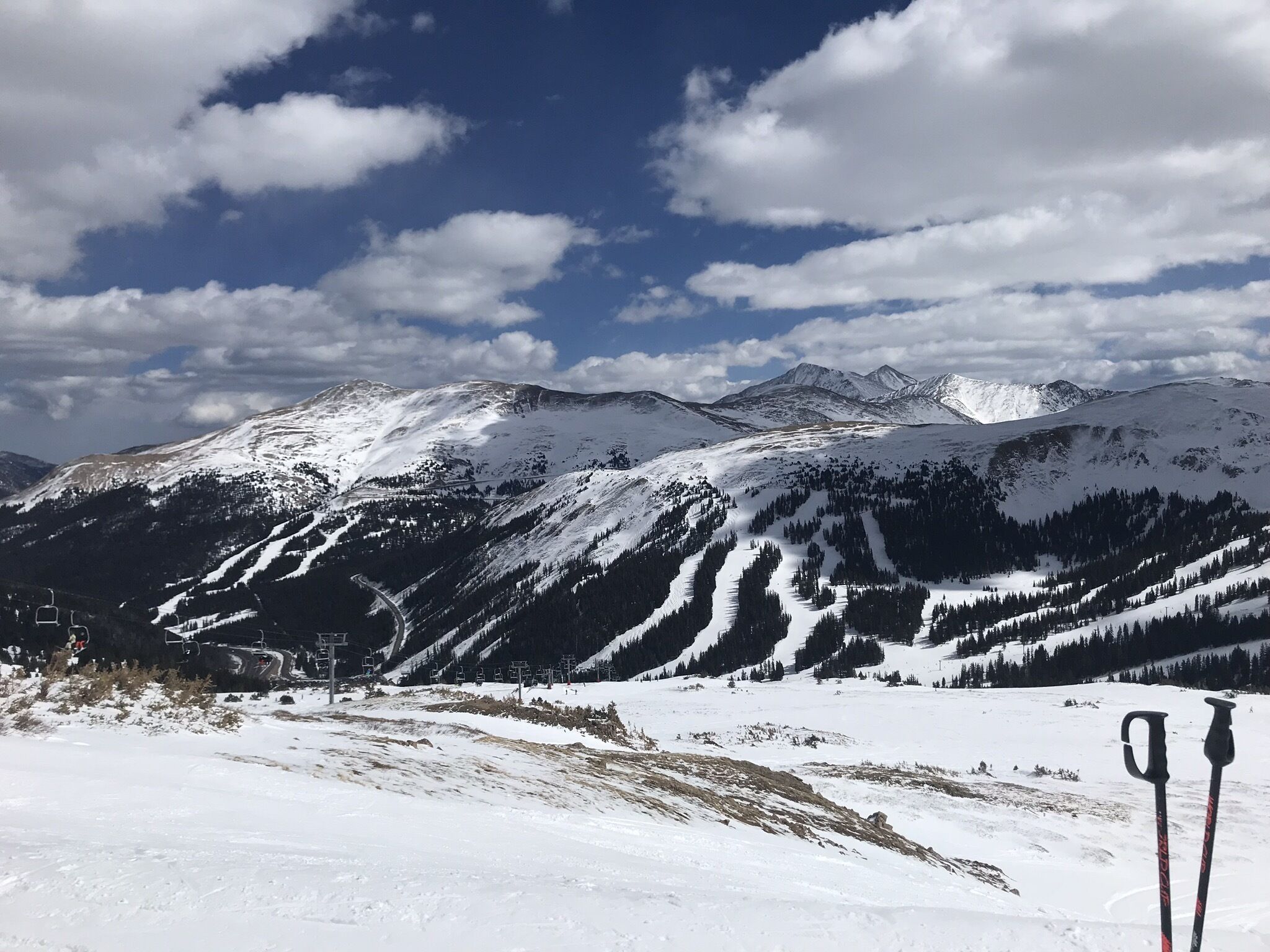 Eine verschneite Berglandschaft mit Seilbahnen und blauem Himmel.