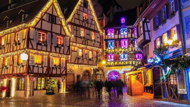 A historic European town square with traditional half-timbered buildings, illuminated by festive lights. - Charming 4* chalet with panoramic view, south-facing, sleeps 6. (Gérardmer)